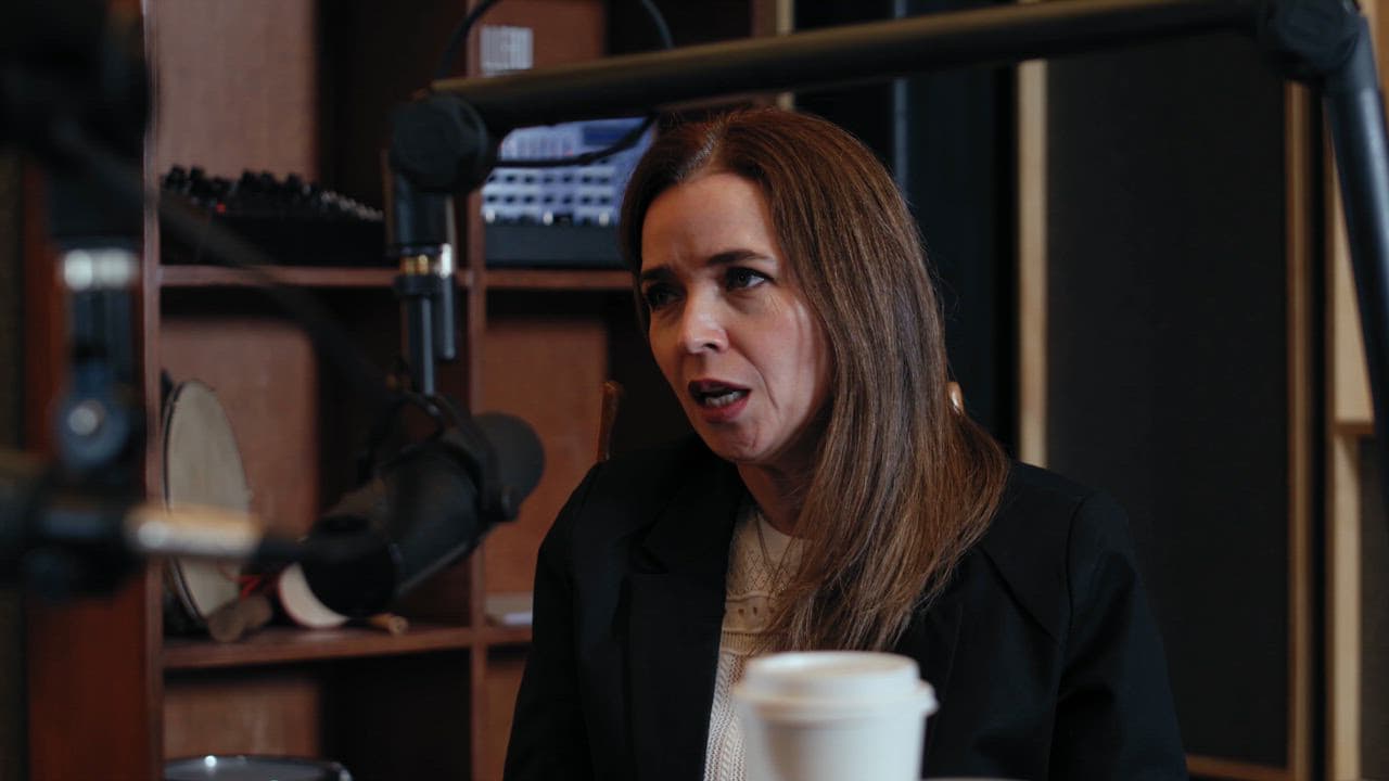 A woman sharing an idea into a podcast microphone in a recording studio